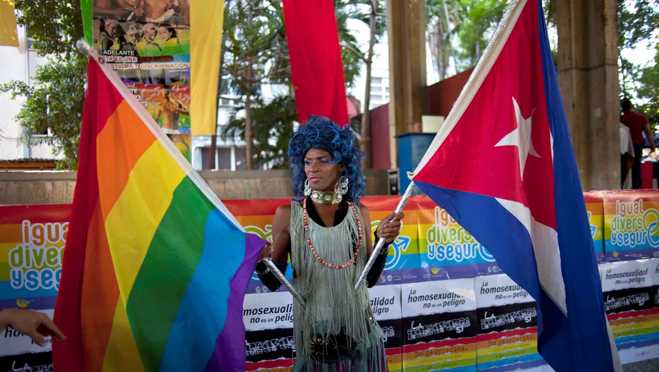 Drag queen holding a gay rights and Cuban flag, posing for photographers during International Day Against Homophobia celebrations in Havana, Cuba.